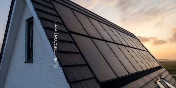 Ein modernes Hausdach mit integrierten Solarpaneelen, die in die Dachziegel eingebettet sind. Die Sonne geht im Hintergrund unter und taucht die Szene in ein warmes Licht. Die Quelle des Bildes ist CREATON | Media.